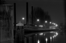 854582 Gezicht op het Merwedekanaal en de Kanaalweg te Utrecht, bij nacht, met de schoorstenen van de ...
